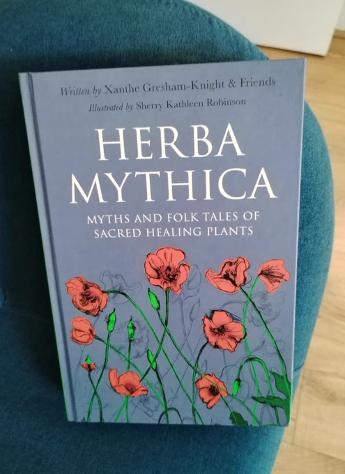 A book cover, blue with red flowers. Title reads: Herba Mythica, Myths and Folk Tales of Sacred Healing Plants.