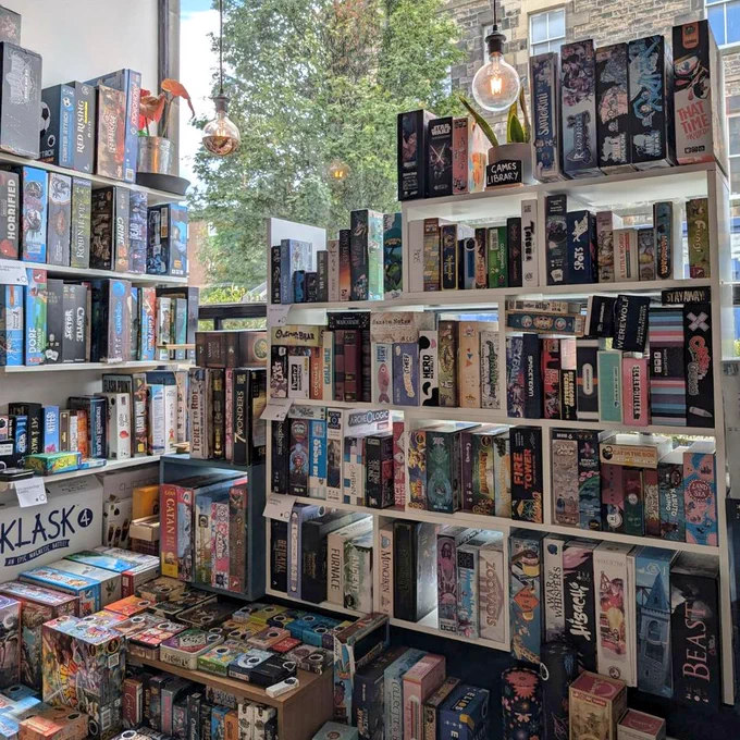 The board game library in Ancient Robot Games. There are two shelves of games, one with two player games, party games and general games, one with cooperative games.