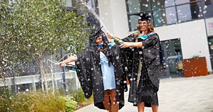 Graduates spraying wine