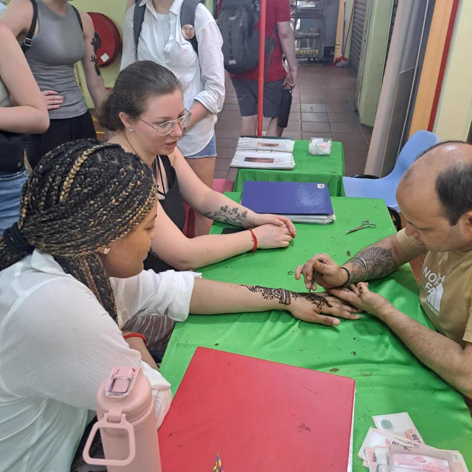 Students get henna applied to their hands