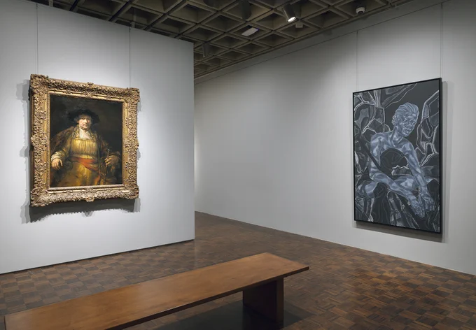 Gallery view of a large portrait of a man on one wall and a large contemporary painting on another wall