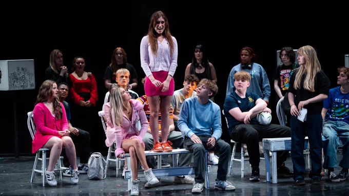 Young people on stage with a girl standing on a bench