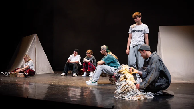 Young people in a campsite on stage