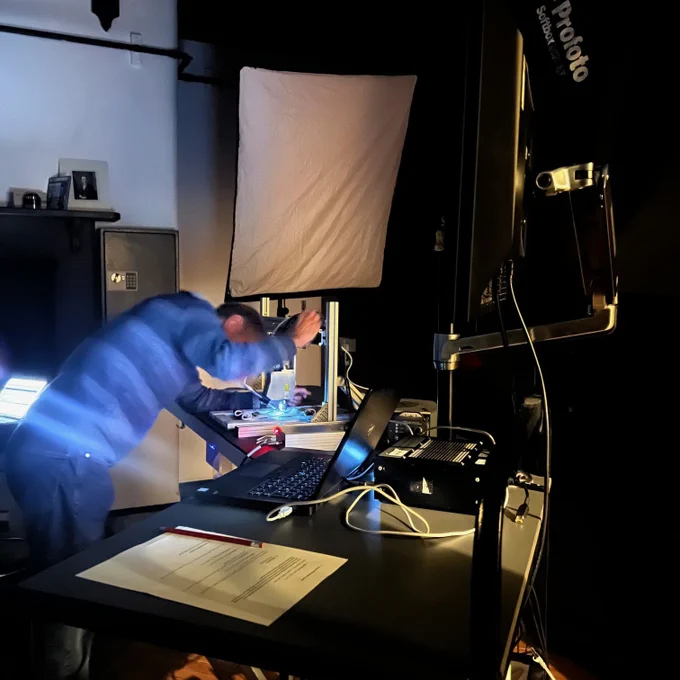A photography studio with a man setting up equipment 