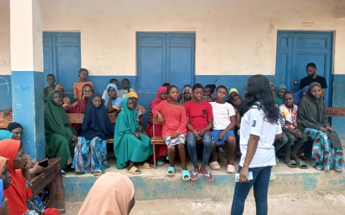 In Nigeria, Gem Hub Initiative's founder and executive director Oyeyemi Pitan speaks to a group of young community members.