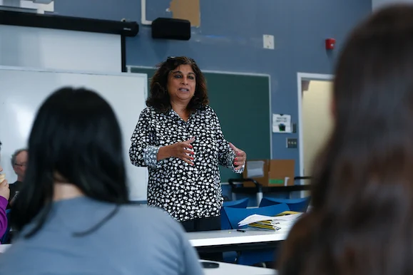 A woman speaks to students in a classroom