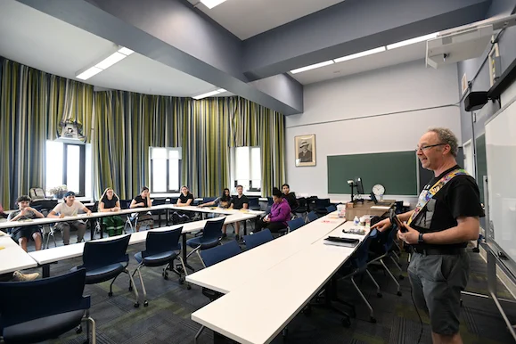 An instructor uses an electric guitar during a workshop on math and music