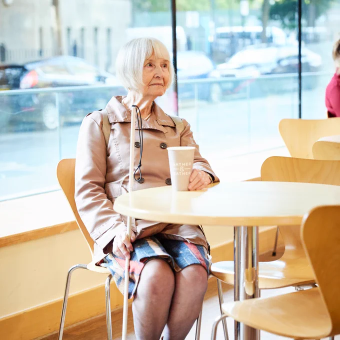Elaine Manna sitting at a table with a cup.