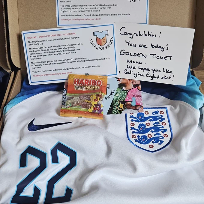 A Surprise Shirts customer's photo of their order, which is England's white 2022 home shirt with #22 print on the front, which of course was Jude Bellingham's number. The shirt is laid out on the Surprise Shirts box.