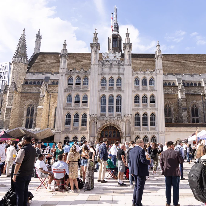 People gathered in Guildhall Yard with the historic Guildhall in the background.