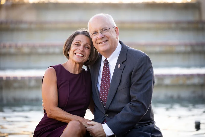 Clif and Gail Smart smiling and sitting closely together in front of the fountain.