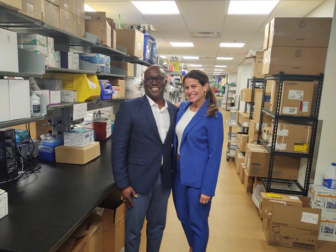 Dr. Duane Mitchell and the CEO of Live Like Bella pose for a photo in a lab.