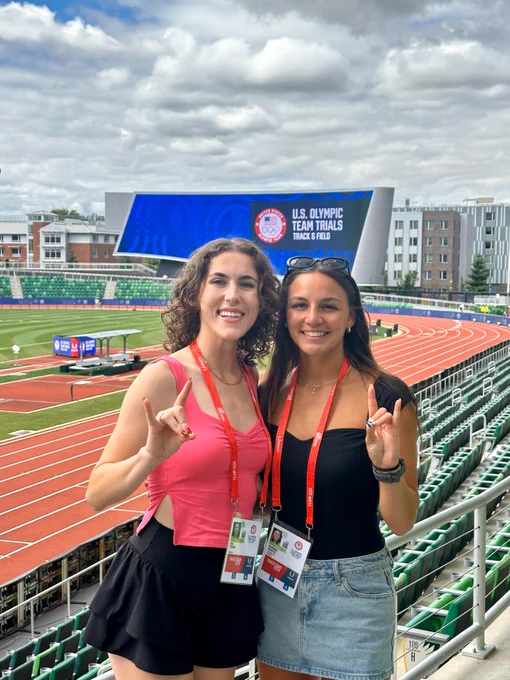 Mia and Marissa smile within the Hayward Stadium and hold their hands in a "foxes up" sign