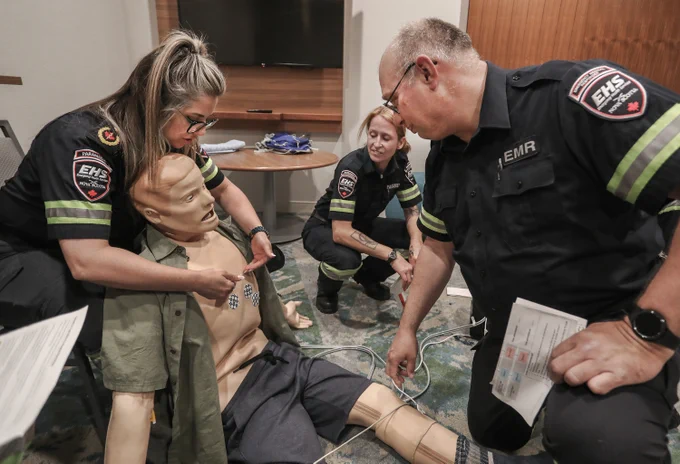 Photo of two paramedics instructing an emergency medical responder in training