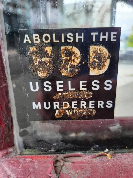 Abolish the VPD, useless murderers sticker on glass.