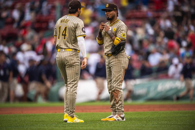 Photo of Tyler Wade and Luis Arraez interacting after today's win in Boston. Both are wearing the Padres sand road pinstripes uniform.