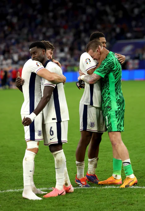 Marc Guéhi, John Stones, Jude Bellingham and Jordan Pickford hug at full-time. 