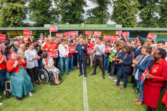 Keir Starmer making a speech with Alistair Strathern amongst Labour supporters at Hitchin football club