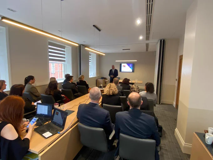 People seated in a room listening to a presentation