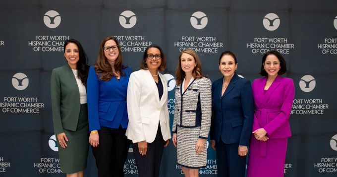 President Cowley poses with the panelists in front of a FWHCC backdrop.