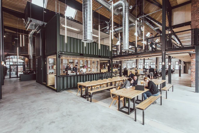 Internal photo of a kitchen and workspace area in Albert Works, Sheffield (Cartwight Pickard). Judges said: "The result is an invigorating space loved by all. Bespoke carpets take inspiration from the previously derelict building, using colours of rust, moss and concrete to integrate seamlessly with the original fabric."