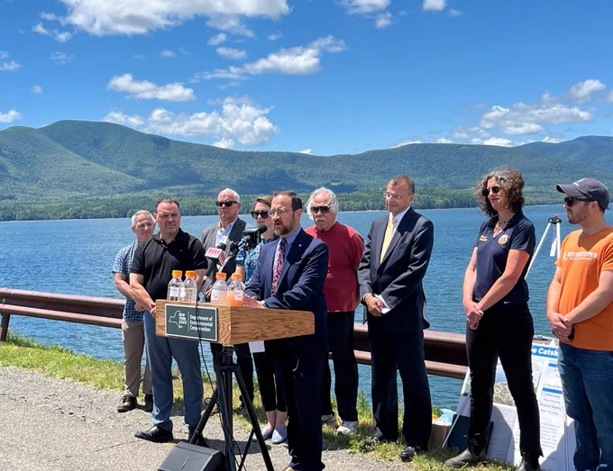 DEC Interim Commissioner, Sean Mahar, speaking at a podium at the Ashokan Reservoir while a group of people stands behind him.