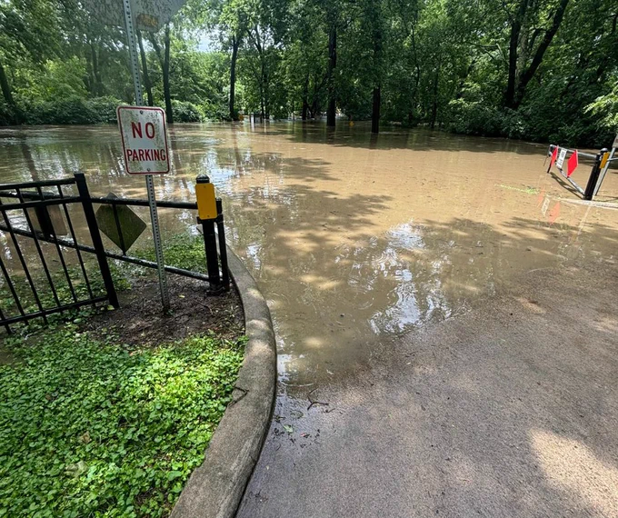 Floodwaters in a parking lot for an access point for trailhead in Mill Creek Streamway Park