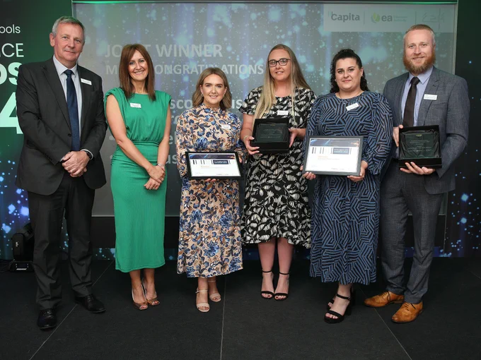 Richard Pengelly, EA CEO, and Linsey Farrell, DE Deputy Secretary for Education Policy, present the ‘Partnerships’ award at the ICT Excellence Awards to are Naíscoil agus Bunscoil Bheanna Boriche