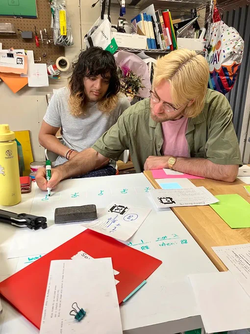 two people writing on a whiteboard