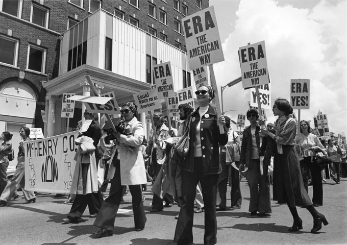 Women holding signs that say "ERA" march through the streets of Springfield in 1982 as part of an Equal Rights Amendment rally.