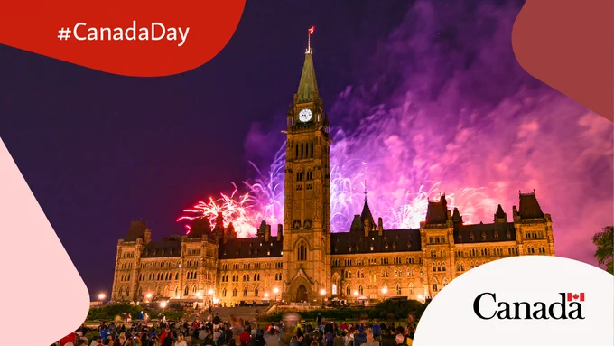 Fireworks illuminate the night sky behind the Canadian Parliament building, with a crowd gathered on the lawn.