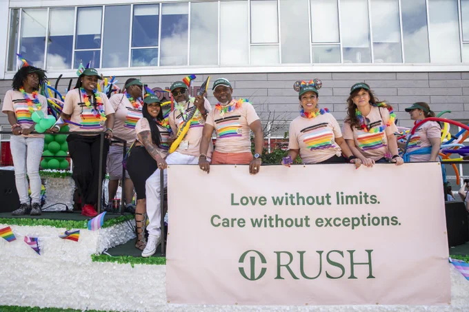 Group of Rush staff members holding a banner that reads "Love without limits. Care without exceptions." 