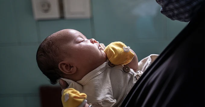 An Indonesian woman holding a baby. 