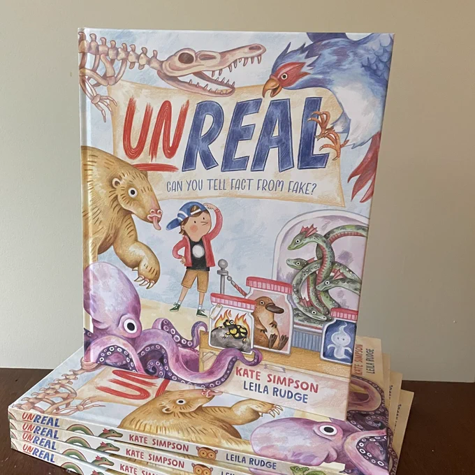Book Unreal. The cover features a kid standing among strange looking creatures scratching his head. Some of the creatures are in jars.