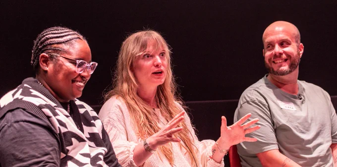 Danielle Small, Nicole Michaelis and Mario Ferrer on stage looking animated