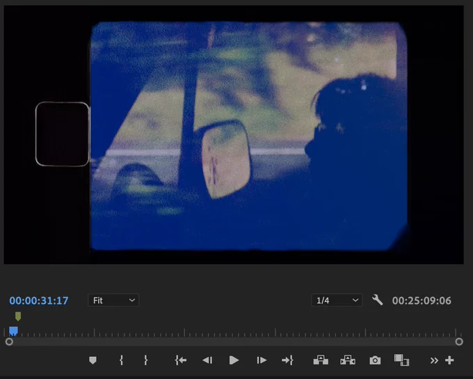 Premiere screenshot of a Super 8-style shot of my friend driving her van with the forest reflected in the window. 