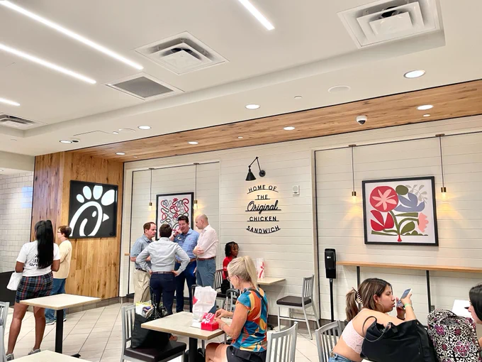 The interior of Chick-fil-A, with customers dining in seats and others waiting in line.