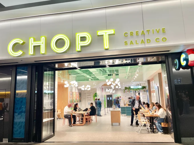 Chopt Creative Salad Co's storefront at the LIRR Concourse at Penn Station, filled with customers and employees inside.