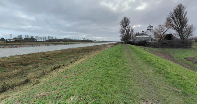 rural scene in winter from Google Maps. a grassy bank next to a river. an interesting short lighthouse on either side. 