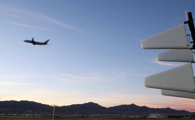 A plane flies through the sky with mountains in the background. D-Fend Solutions' technology is on the right side of the image.