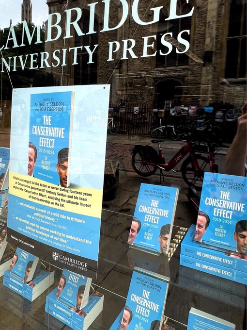 Window display for The Conservative Effect.  Books facing out, placed around large showcard with review quotes about the book