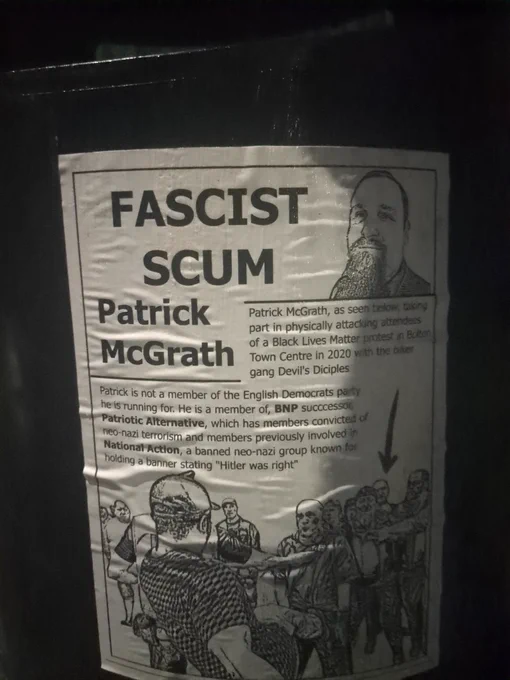Poster reads: "FASCIST SCUM Patrick McGrath. Patrick McGrath, as seen below, taking part in physically attacking attendees of a Black Lives Matter protest in Bolton town centre in 2020 with the biker gang, Devil's Diciples." Below this is a black and white image of the clashes, with McGrath marked with an arrow. Above is a portrait of him. Below reads: Patrick is not a member of the Englsh Democrats party he is running for. He is a member of BNP successor Patriotic Alternative, which has members convicted of neo-nazi terrorism and members previously involved in National Action, a banned neo-nazi group known for holding a banner stating "Hitler was right"
