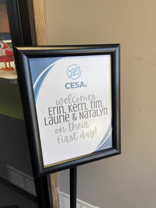 Sign outside door welcoming new staff members by name. Sign says “CESA 6 welcomes Erin, Kerri, Tim, Laurie, and Natalyn on their first day!”