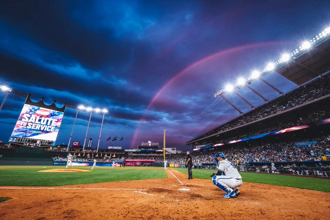 Salvador Perez receives a warm-up pitch as a rainbow arches across the sky behind Kauffman Stadium. (Photo by Jason Hanna/Kansas City Royals)