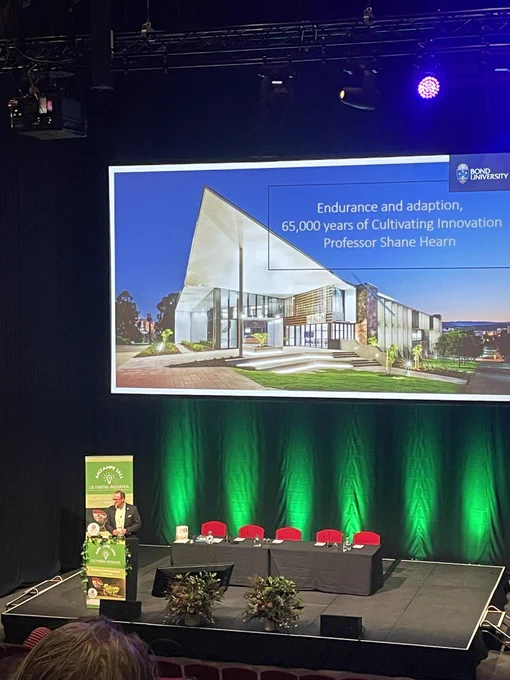 Professor Shane Hearn on the stage in front of his opening slide