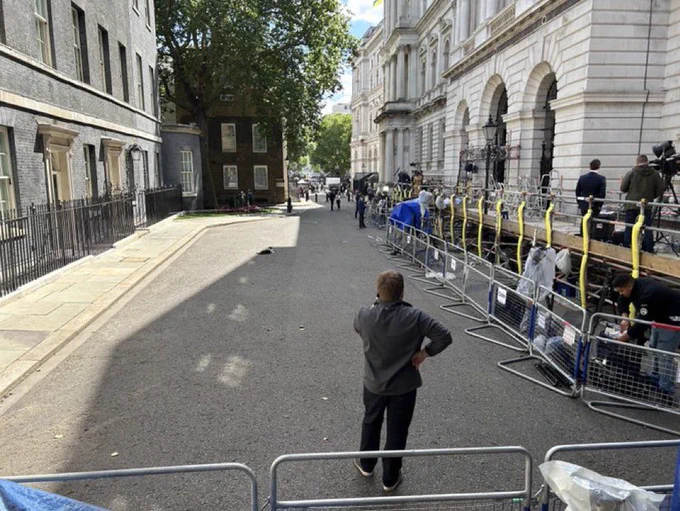 Larry laying on Downing Street with press scaffolding erected