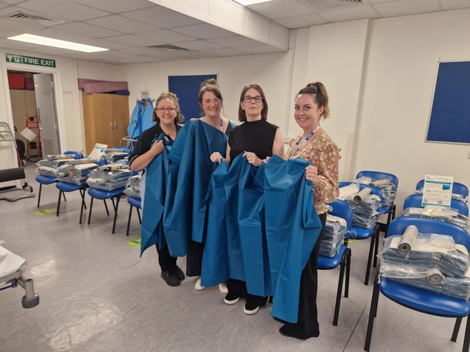 Four of the team involved in the project, displaying the reusable sheets