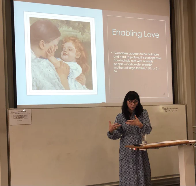 Photo of McMullin speaking in front of a slide of a quote from Iris Murdoch explaining her conception of enabling love.
