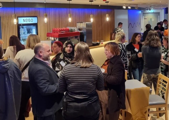 Groups of people standing and chatting in ARC's No 60 cafe bar