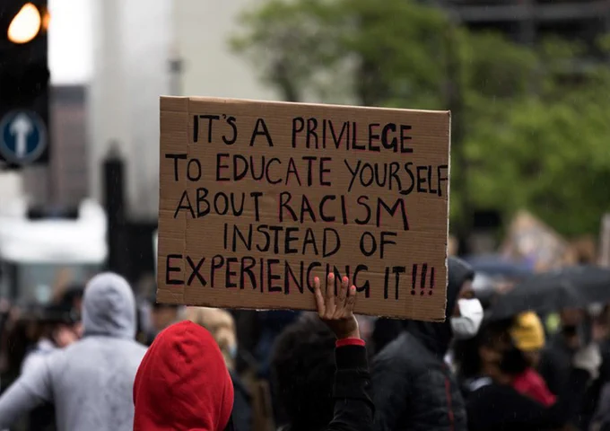 A sign being held up by a protester in 2020 that reads: "It's a privilege to educate yourself about racism instead of experiencing it!!!"